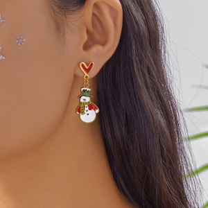 Gros plan d'une boucle d'oreille bonhomme de neige de Noël avec clou en cœur rouge