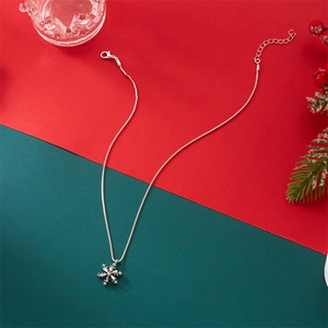 Detailed view of silver snowflake pendant necklace with crystals on festive background