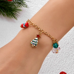 Nahaufnahme eines Weihnachts-Charm-Armbands mit Anhängern am Handgelenk des Modells