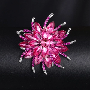 Gros plan d'une broche feuille d'érable rose avec pétales en cristal et strass