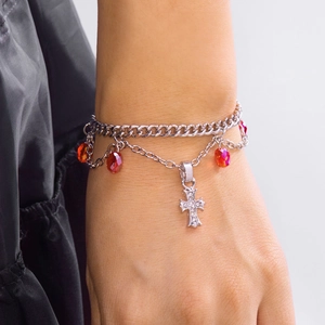 Détail de la chaîne double argentée avec cristaux rouges et pendentif en croix
