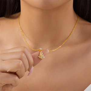 Close-up of a model wearing a gold Christmas tree necklace with white zircon pavé