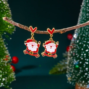 Détail de boucles d'oreilles Père Noël avec cœurs rouges suspendus à une branche