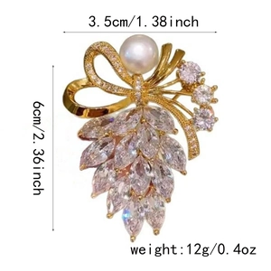 Détail de la broche nœud en cristal avec perle blanche et dimensions 3,5x6cm
