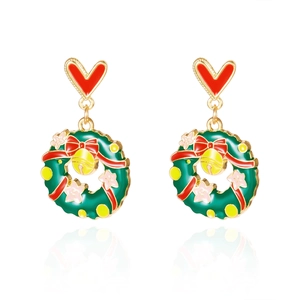 Détail de boucles d'oreilles couronne de Noël avec nœuds rouges et cloches