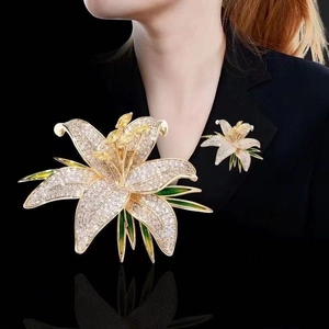 Élégante broche fleur de lys avec cristaux blancs et feuilles en émail vert pour femme
