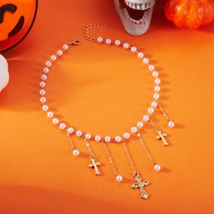 Détail d'un collier de perles avec croix dorées sur un fond orange décoratif de Halloween