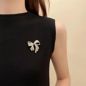 Détail macro d'une broche nœud argentée avec oxydes de zirconium sur tissu noir