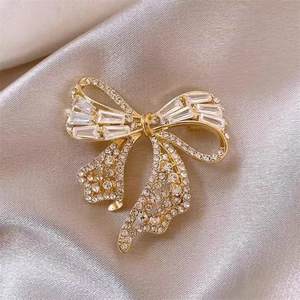 Détail de la broche nœud doré sertie de strass et de zircons à coupe baguette