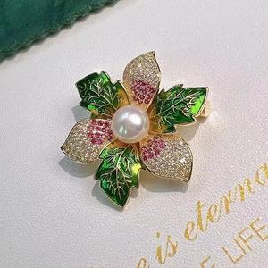 Détail d'une broche feuille d'érable avec cristaux roses, émail vert et perle centrale