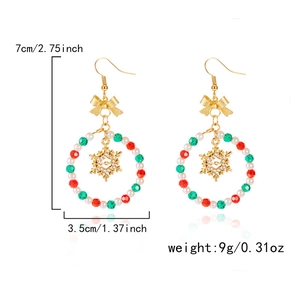 Macro detail of Christmas hoop earrings with red green beads and white snowflake charm
