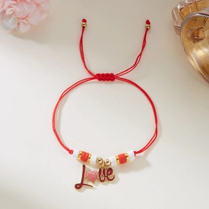 Detalle de la pulsera de cuerda roja tejida con colgante Love y diseño de corazón pequeño