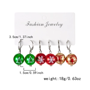 Vue détaillée des boucles d'oreilles boules de Noël colorées avec motifs festifs
