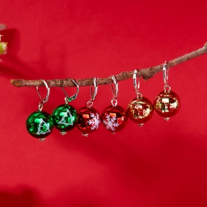 Lot de boucles d'oreilles boules de Noël avec motifs sapin et flocons sur une branche