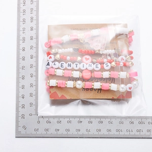 Coffret détaillé de bracelets de perles de la Saint-Valentin sur emballage en carton kraft