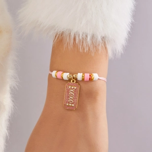 Detalle macro de pulsera XOXO hecha a mano con cuentas de arcilla rosa y blancas