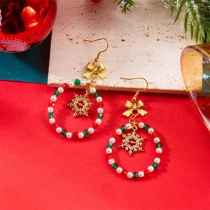 Macro detail of Christmas hoop earrings with beaded ring and golden snowflake charm