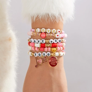 Détail de bracelets extensibles multicouches avec breloques cœur rose et lettres d'amour