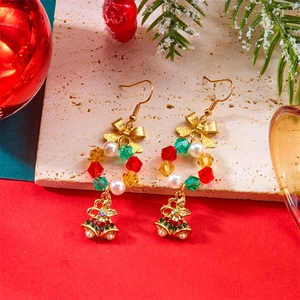 Detailed view of Christmas hoop earrings with beads, bow tie, and festive double bells