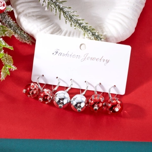 Vue détaillée de trois paires de boucles d'oreilles boules de Noël sur carte de support