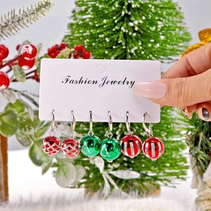 Détail d'un ensemble de boucles d'oreilles de Noël aux motifs festifs sur carte blanche