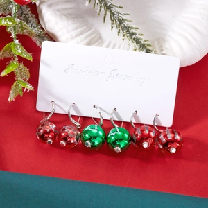 Vue détaillée d'un ensemble de boucles d'oreilles de Noël sur carte avec décor de sapin