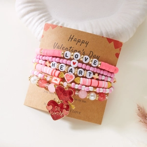 Détail d'un ensemble de bracelets en perles roses avec cœurs sur une carte de la Saint-Valentin