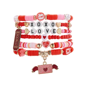 Détail de bracelets multicouches à perles avec breloques LOVE et XOXO pour la Saint-Valentin
