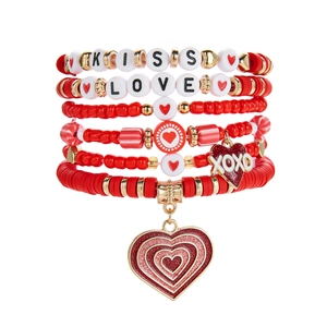 Détail de bracelets multicouches cœur avec perles KISS LOVE et pendentif rouge brillant