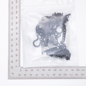 Macro view of multi-layer black OT buckle heart necklace inside frosted packaging