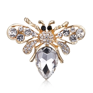 Detailed view of a gold bee brooch with sparkling crystals and a large pear-cut stone