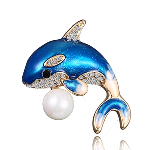 Detailed macro of a dolphin brooch with blue enamel, crystals, and a white pearl