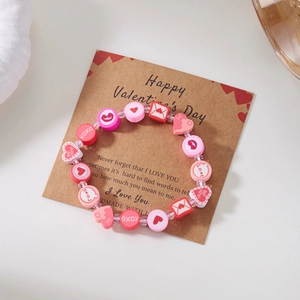 Dettaglio del bracciale di San Valentino con perline e motivi XOXO su un biglietto