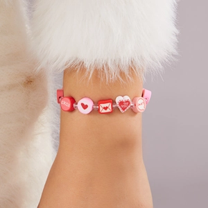 Dettaglio del bracciale con perline di argilla a cuore e scritte XOXO e BE MINE