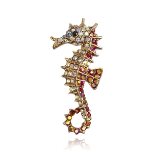 Detailed view of vintage gold seahorse brooch with colorful inlaid crystals and black eye