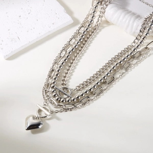 Macro shot of silver layered necklace with heart pendant and vintage toggle clasp