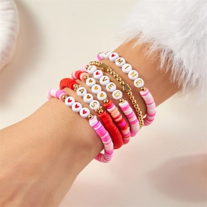 Detail eines mehrlagigen Boho-Armband-Sets mit rosa Perlen und 'BE MINE' Anhängern