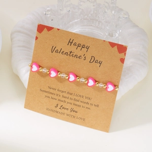 Dettaglio macro del bracciale di San Valentino fatto a mano con cuori rosa su card regalo