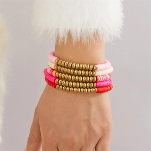 Detail von 5 mehrlagigen rosa Herz-Perlenarmbändern am Model mit Pelzhintergrund