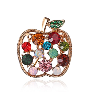 Detail of apple-shaped gold brooch with colorful rhinestones and sparkling crystal inlays