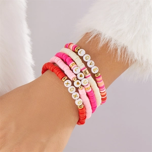 Detail von mehrlagigen Polymer-Ton-Armbändern mit rosa Herzanhängern und LOVE-Perlen