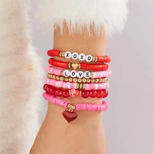 Detail von geschichtetem Valentinstag-Perlenarmband-Set mit XOXO-Herzanhängern