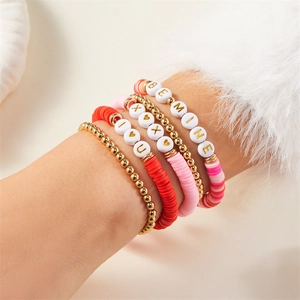 Detail von mehrlagigen Valentinstag Armbändern mit Herzanhängern und romantischen Perlen