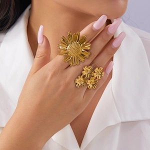 Detailed view of gold sunflower ring set worn on model fingers with floral design