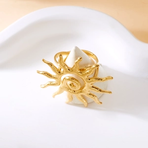 Macro detail of golden sunburst ring with spiral center on minimalist white display