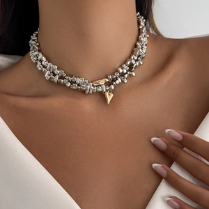 Dettaglio della collana a strati con perle argentate e ciondolo a cuore dorato
