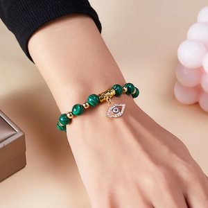 Bracelet en perles de malachite naturelle avec pendentif mauvais œil porté au poignet
