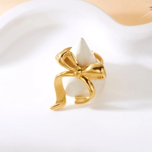 Detailed view of polished golden bow ring with reflective finish and adjustable band