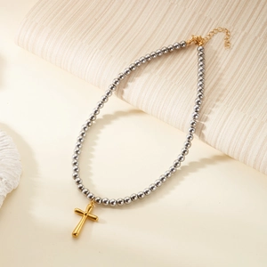 Detail of grey beaded necklace featuring a golden cross pendant and OT buckle closure