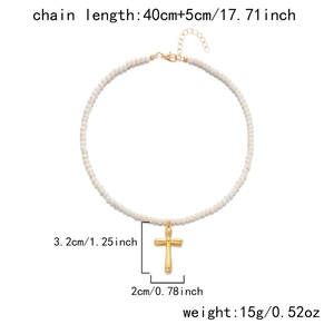 Detail of cross necklace with white marble beads and adjustable gold stainless steel extension